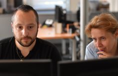 Dwie osoby pracujace przy komputerze. Grafika ilustracyjna e-umowa w ofercie dla firm w Orange Polska